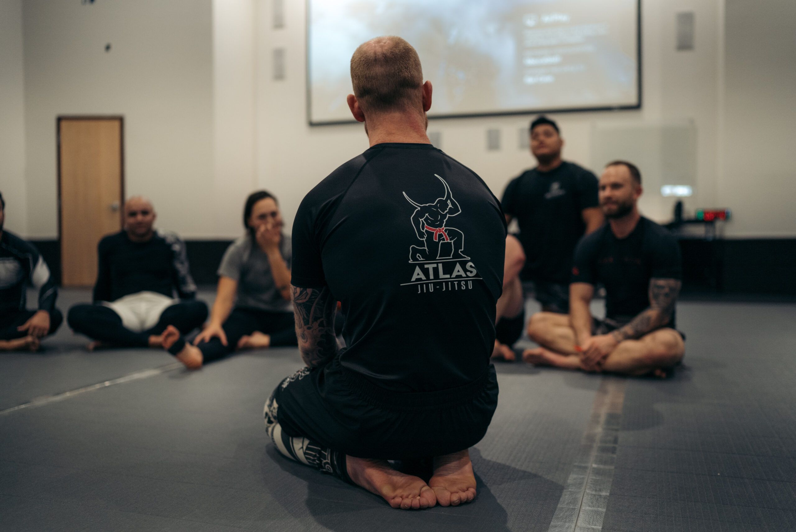 Head instructor Chase Riddick teaching a seated group of students