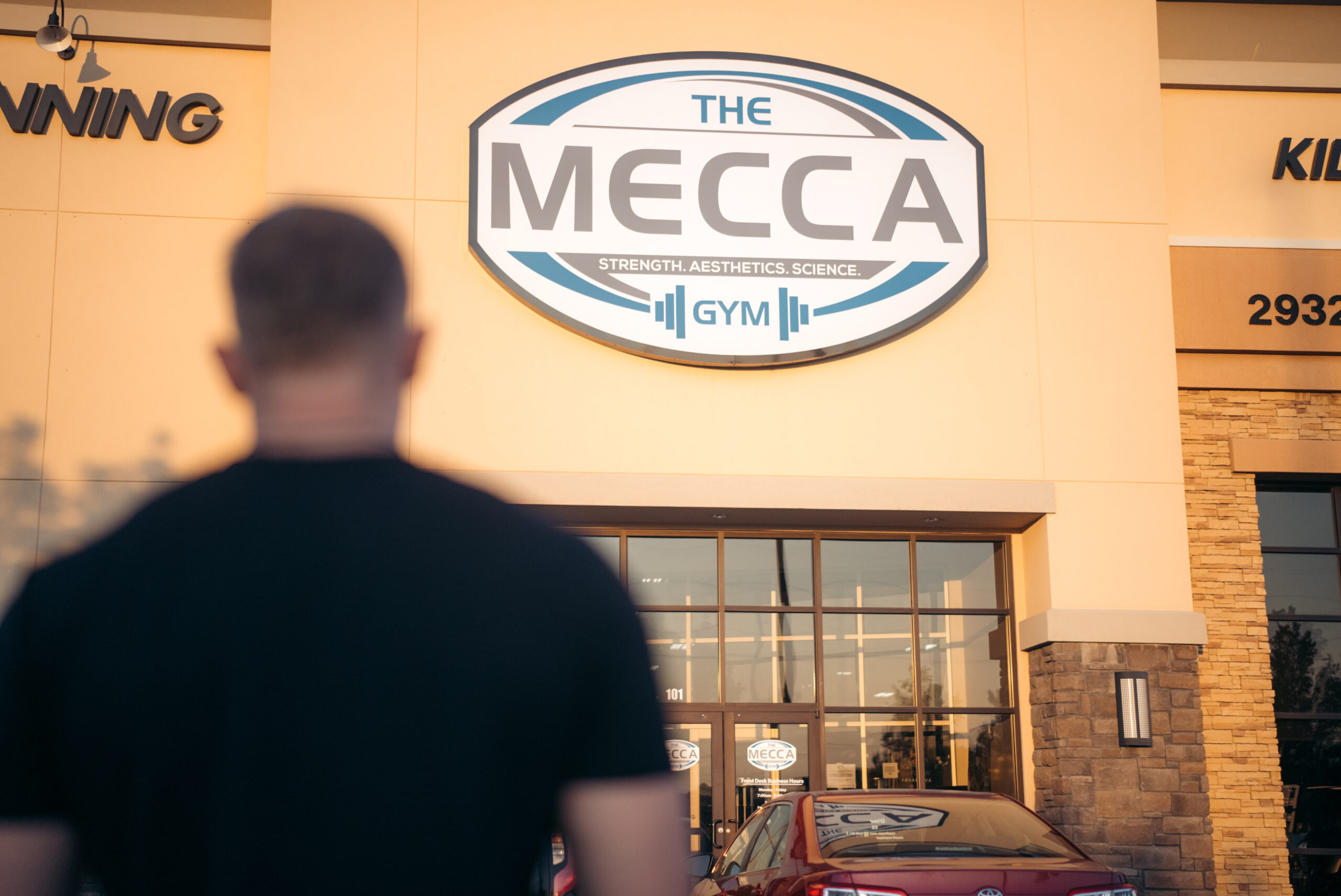 member standing in front of mecca gym building